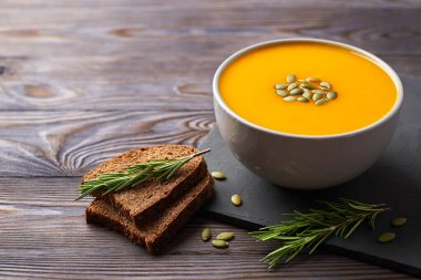 Tohum ve biberiyeyle süslenmiş kabak püresi çorbası. Vejetaryen yemeği.