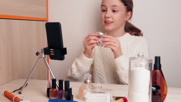 Élégant jeune fille blogueur montre ses bijoux aux abonnés. Ça t'apprend à être élégant. Enregistre une vidéo pour un blog sur les réseaux sociaux à l'aide d'une caméra smartphone sur un trépied . — Video