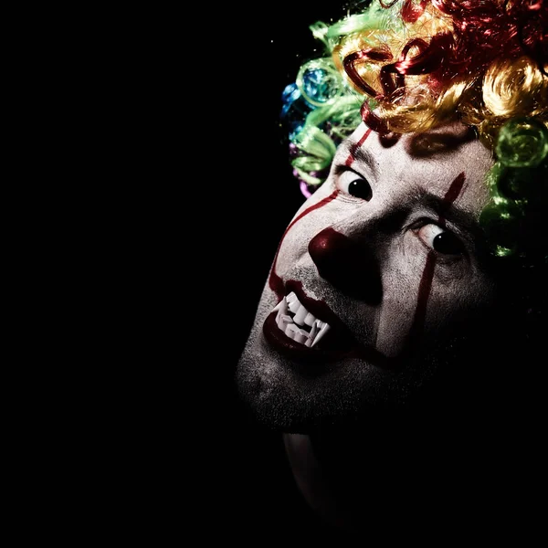 Detailní portrét strašidelného klauna v barevné paruce. Černé prázdné místo vlevo — Stock fotografie