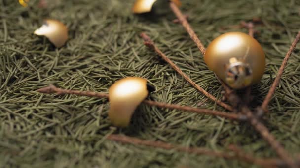 Zlomené zlaté vánoční koule leží na suchých padlých jehličích a větvích vánočního stromku. Detailní záběr, 4k. — Stock video