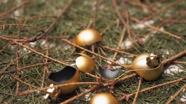 Le palle di Natale d'oro rotte si trovano su aghi caduti secchi e rami di un albero di Natale. Primo piano, 4K, lasciando la videocamera dal soggetto . — Video Stock