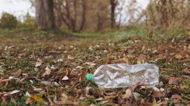 Ekolojik kavram, plastiği durdur. Yakın plan, bilinci açık bir gönüllü tahta maşayla plastik bir şişeyi alıp bir torbaya koyuyor..