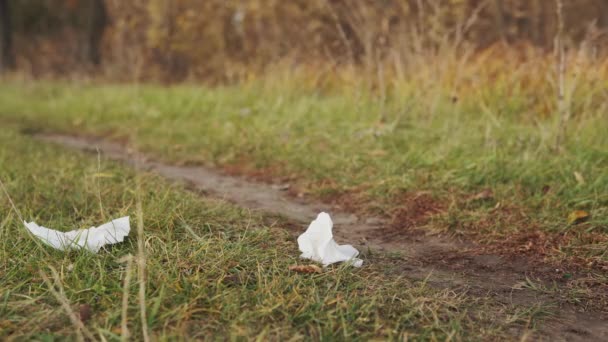 Gebruikte natte doekjes liggen op het gras. Milieuverontreinigingsconcept. — Stockvideo