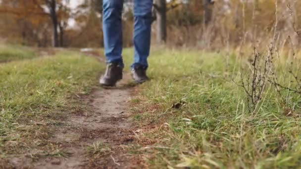 Concetto ecologico inquinamento plastico. Un uomo irresponsabile in blue jeans getta una bottiglia di plastica sull'erba verde del parco . — Video Stock