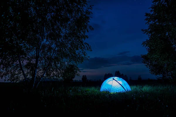 Ormanda kamp yapmak. Geceleri ağaçların arasında aydınlatılmış küçük bir çadır.. — Stok fotoğraf