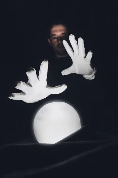 Посланник тримає руки в білих рукавичках над чарівною кришталевою кулею. Сесія для передбачення майбутнього . — стокове фото