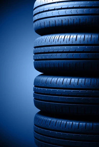 Quatro pneus de verão de carro em iluminação dramática. Tonificação na cor da moda 2020 clássico azul . — Fotografia de Stock
