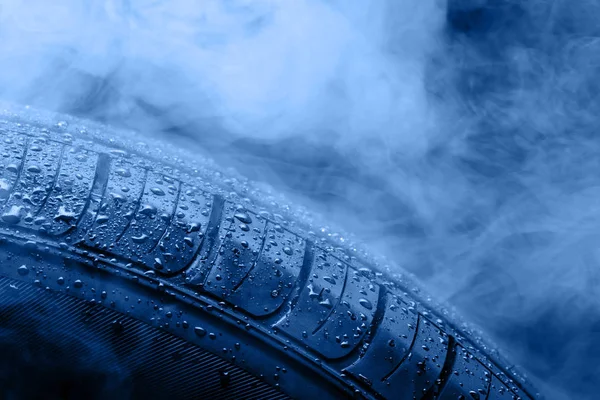 Opona samochodu pokryta kroplami wody we mgle. Tonizujący w modnym kolorze 2020 classic blue. — Zdjęcie stockowe