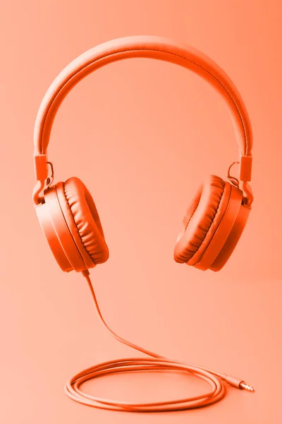 Minimální složení sluchátek. Tónovaný v módní barvě svěží lávy. — Stock fotografie