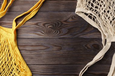 Ahşap bir masada yeniden kullanılabilir ağ ürünü poşeti, üst manzara. Sıfır atık.