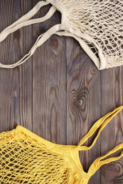 Ahşap bir masada yeniden kullanılabilir ağ ürünü poşeti, üst manzara. Sıfır atık.