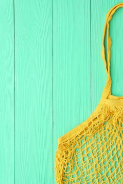 Ahşap bir masada yeniden kullanılabilir ağ ürünü poşeti, üst manzara. Sıfır atık.