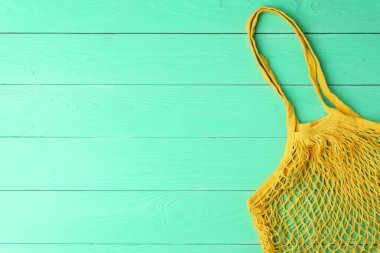 Ahşap bir masada yeniden kullanılabilir ağ ürünü poşeti, üst manzara. Sıfır atık.