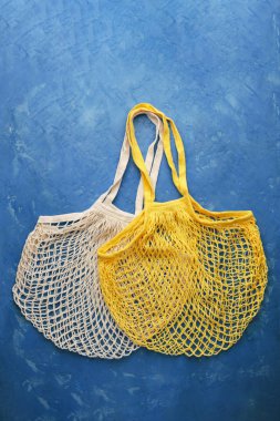Reusable mesh product bag on blue concrete table.