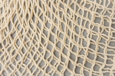 Reusable mesh product bag on a gray table, top view.