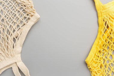 Two reusable mesh product bags on a gray table.