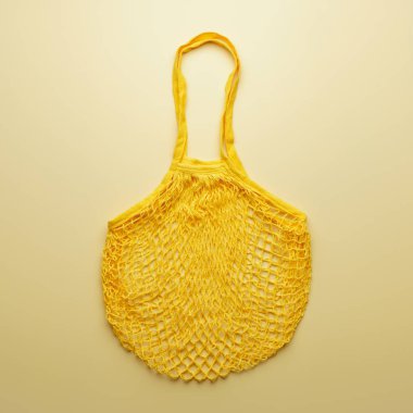 Reusable mesh product bag on yellow background.