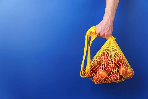 Mão masculina segura um saco de cordas com maçãs vermelhas . — Fotografia de Stock