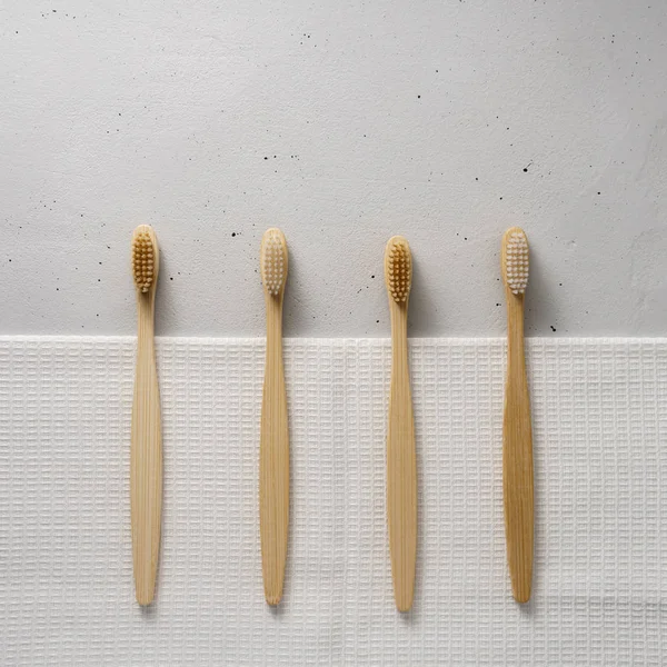 Több bambusz fogkefe egy könnyű beton háttér. Felülnézet másolási hellyel. — Stock Fotó
