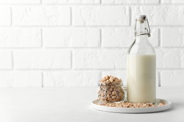 Cam kavanozda nohut fındığı ve beyaz arka planda süt..