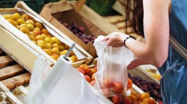 Genç bir kadın süpermarketten meyve alır..