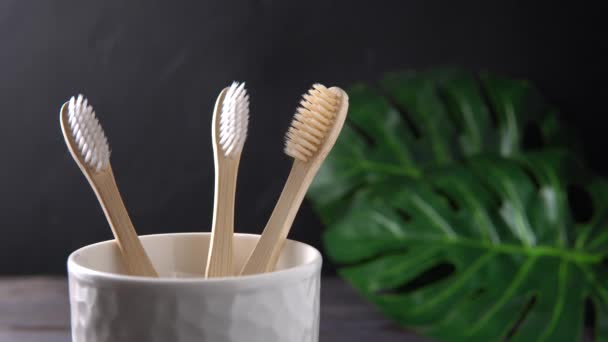 Uma mão masculina leva uma escova de dentes de bambu . — Vídeo de Stock