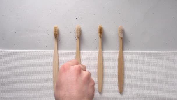 Una mano masculina toma un cepillo de dientes de bambú . — Vídeo de stock