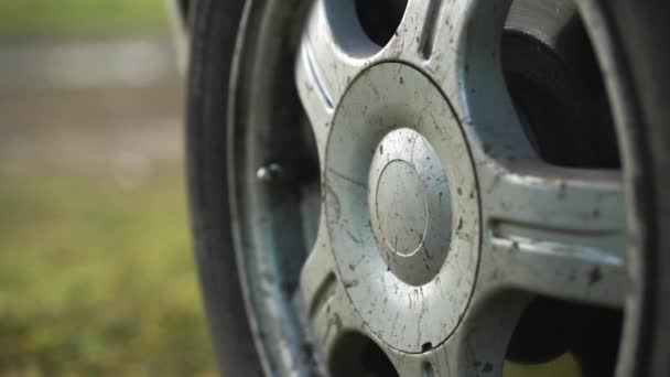 Primo piano mani maschili rimuovere il tappo dalla ruota di un'auto . — Video Stock