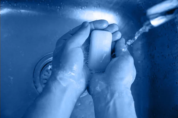 Protezione contro le infezioni da Coronavirus, l'uomo si lava le mani con il sapone sopra il lavandino in acciaio — Foto Stock