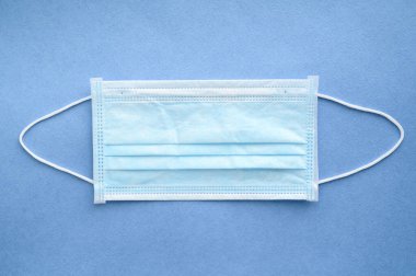 Mavi arka planda tıbbi maske. Ağzı ve burnu korumak için yüz maskesi..