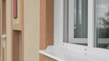 Kafkasyalı yetişkin bir adam pencereyi açar, solunum cihazını çıkarır, etrafa mutlu bir şekilde bakar.