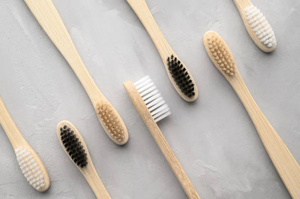 Zero conceito de desperdício. Conjunto de escovas de dentes de bambu ecológicas em um fundo de concreto cinza . — Fotografia de Stock