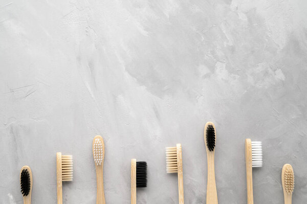 Zero waste concept. Set of eco friendly bamboo toothbrushes on a gray concrete background.
