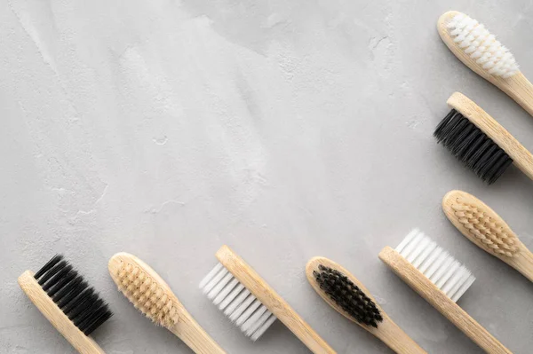 Concepto de cero residuos. Conjunto de cepillos de dientes de bambú ecológicos sobre un fondo de hormigón gris . — Foto de Stock