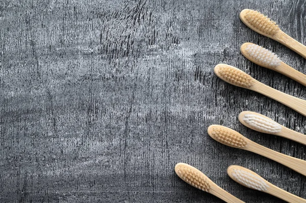 Zero waste concept. Set of eco friendly bamboo toothbrushes on a gray background.