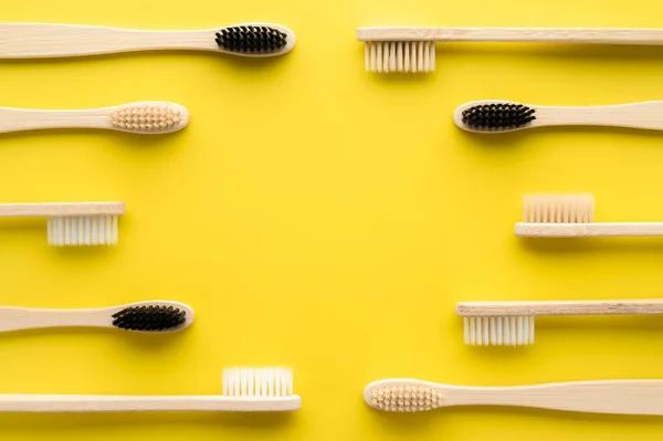Concepto de cero residuos. Conjunto de cepillos de dientes de bambú ecológicos sobre un fondo amarillo brillante . — Foto de Stock