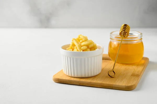 Vit ramekin med chak chak och honung i en burk på ett vitt bord. — Stockfoto