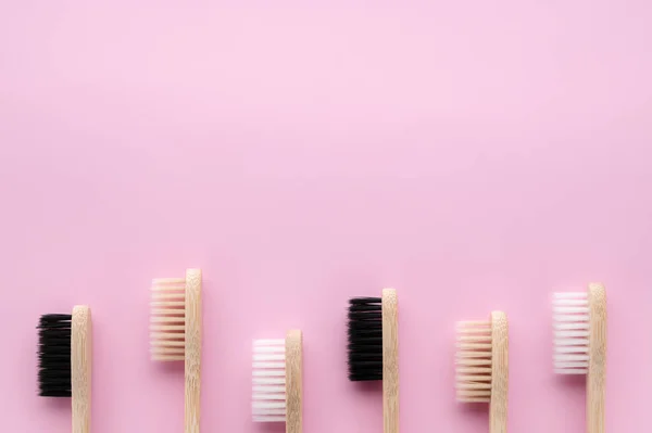 Concepto de cero residuos. Conjunto de cepillos de dientes de bambú ecológicos sobre una superficie de color rosa pastel . — Foto de Stock