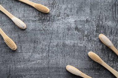 Sıfır atık. Gri ahşap arka planda çevre dostu bambu diş fırçaları..