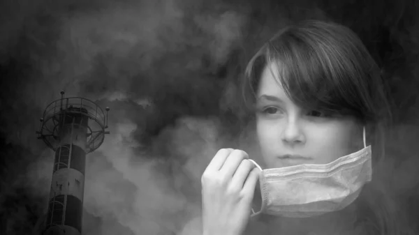 Podwójna ekspozycja, czarno-biały obraz. Nastoletnia dziewczyna zakłada maskę ochronną i przemysłowe rury wydechowe z dymem. — Zdjęcie stockowe