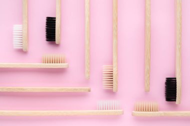 Sıfır atık. Pastel pembe arka planda çevre dostu bambu diş fırçaları..