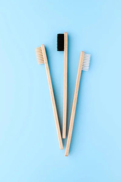Concepto de cero residuos. Conjunto de cepillos de dientes de bambú ecológicos sobre un fondo azul claro . — Foto de Stock