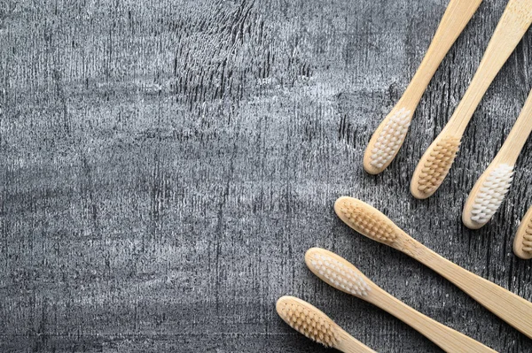 Noll avfallskoncept. Set med miljövänliga bambu tandborstar på en grå trä bakgrund. — Stockfoto