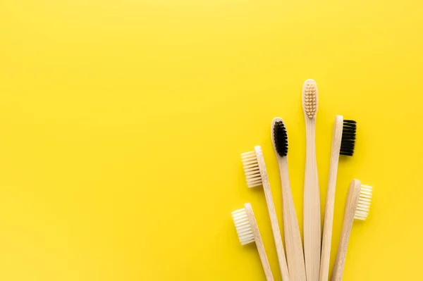 Concepto de cero residuos. Conjunto de cepillos de dientes de bambú ecológicos sobre un fondo amarillo brillante . — Foto de Stock