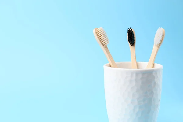 Three bamboo toothbrushes in a white glass. Zero waste and no plastic concept. — Stock Photo, Image