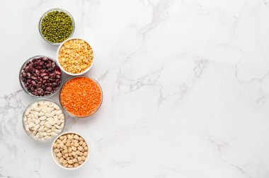 Çeşitli sebze protein kaynakları: fasulye, mercimek, bezelye, nohut, kaselerdeki mung fasulyesi. Vejetaryenler ve vejetaryenler için sağlıklı dengeli bir diyet..