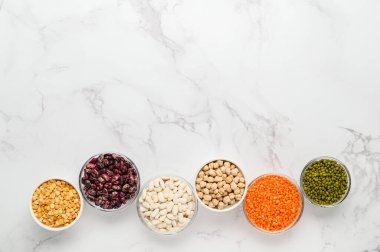 Çeşitli sebze protein kaynakları: fasulye, mercimek, bezelye, nohut, kaselerdeki mung fasulyesi. Vejetaryenler ve vejetaryenler için sağlıklı dengeli bir diyet..