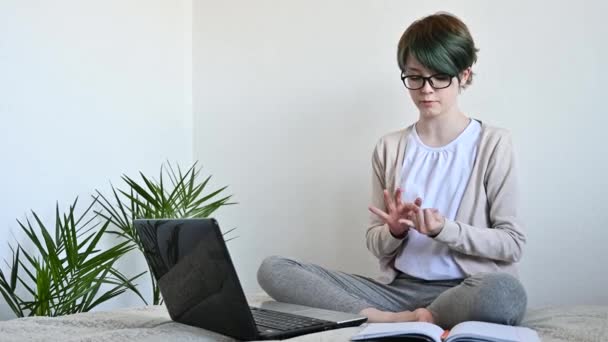 Дистанционное обучение онлайн. Девочка-подросток учится дома на ноутбуке — стоковое видео