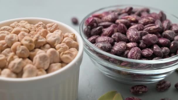 Different types of legumes in bowls on a dark stone table. — Stock Video