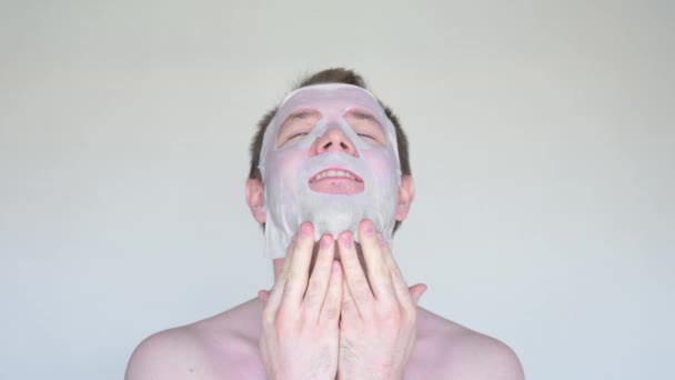 Caucásico hombre cubre su cara con una máscara cosmética . — Vídeo de stock